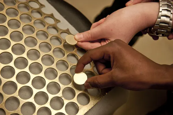 Pupils handling coin blanks and webbing