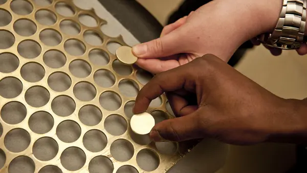 Pupils handling coin blanks and webbing 2